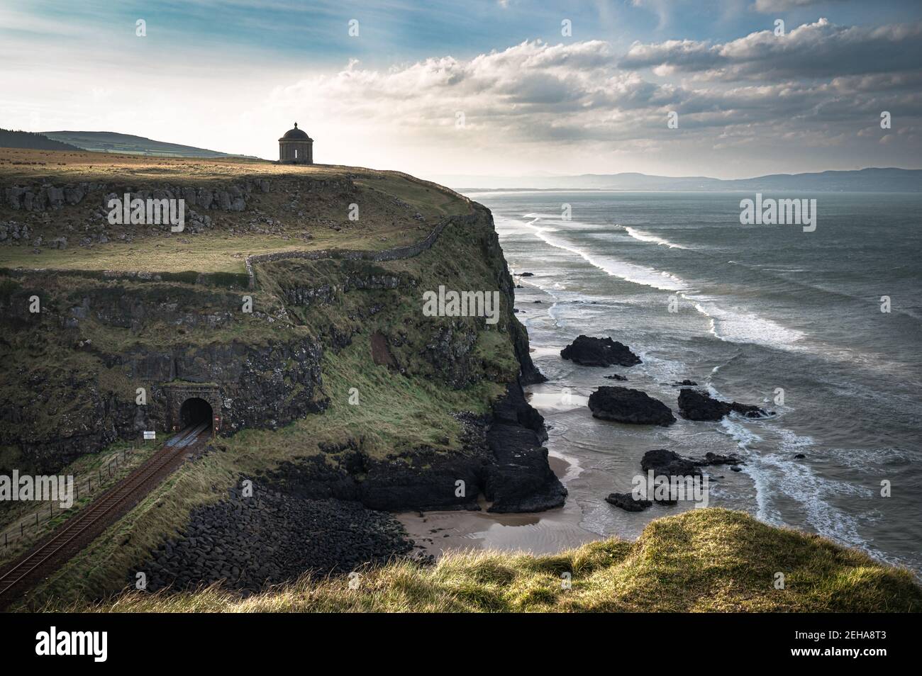 Bahnstrecke entlang der Causeway Coast in Nordirland. Ein Tunnel geht unter den Musseden Tempel Stockfoto