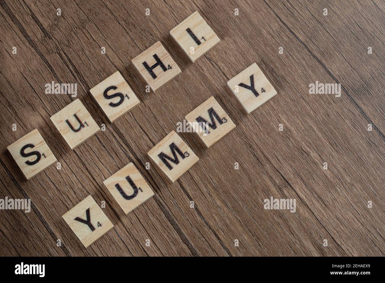 Leckere Sushi-Schrift mit Holzdices auf dem Tisch Stockfoto