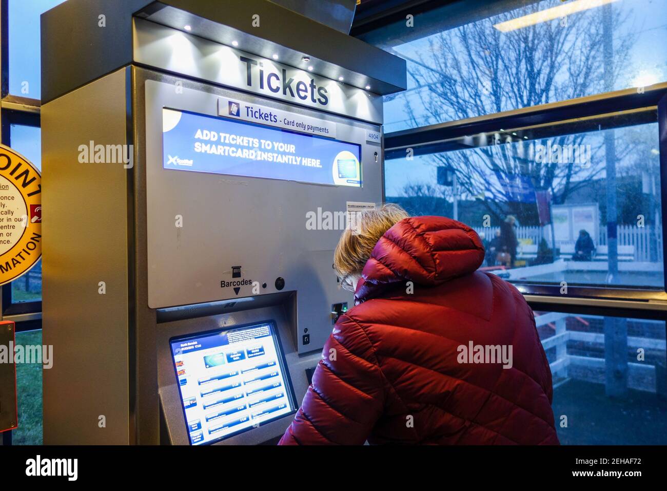 Frau, die ein Zugticket am Selbstbedienungsautomaten kauft Stockfoto