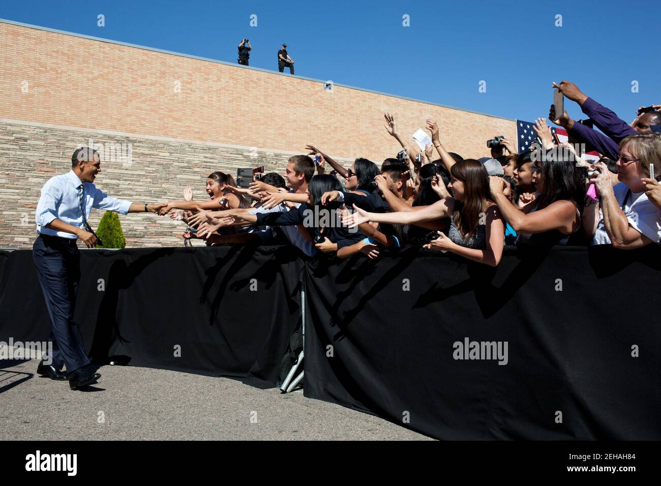 27. September 2011 "der Präsident schüttelt die Hände mit den Studenten, bevor er Bemerkungen zum American Jobs Act an der Abraham Lincoln High School in Denver abgibt. Die breitere Ansicht zeigt auch das Sicherheitspersonal auf dem Dach." Stockfoto