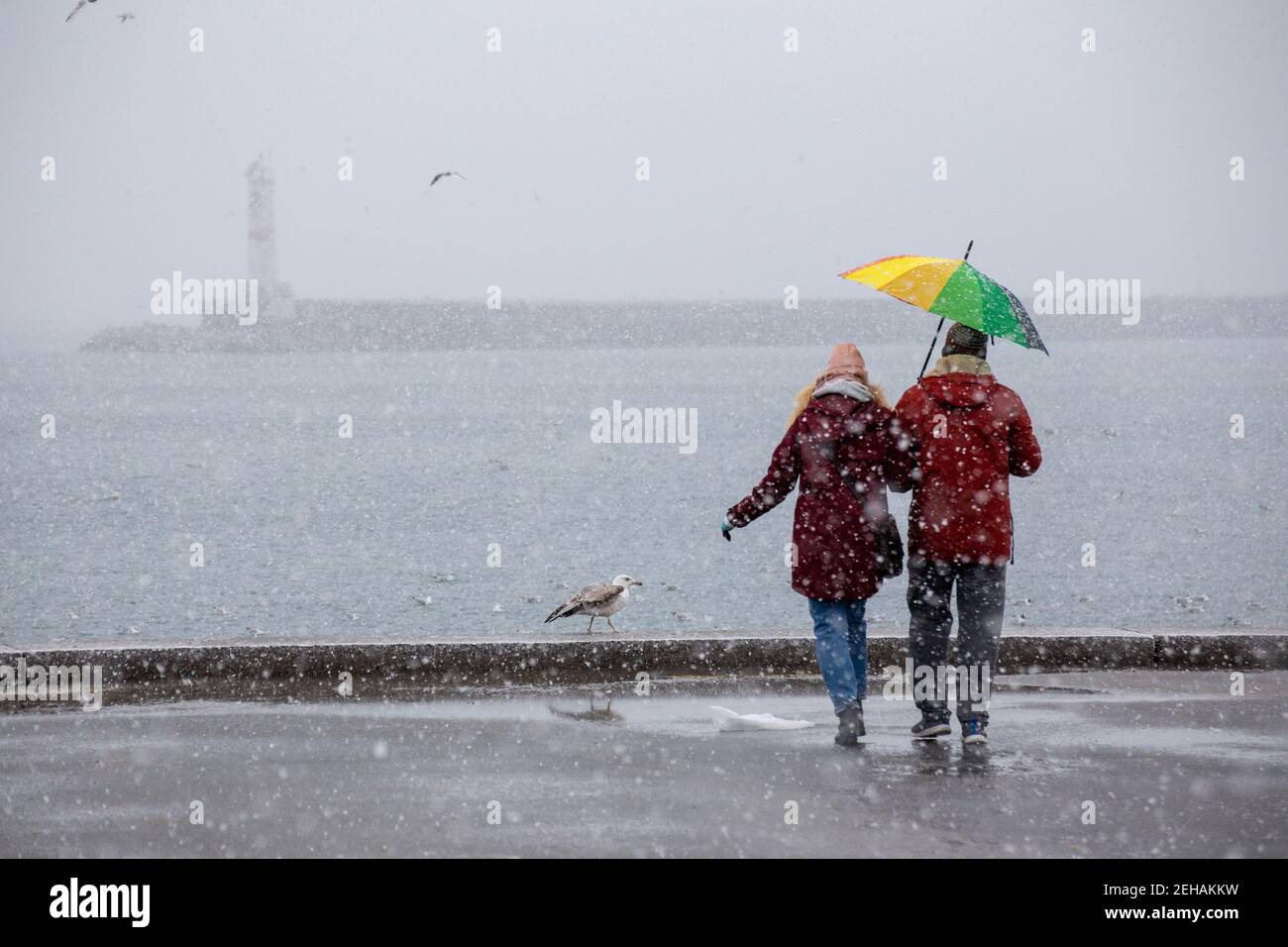 Verliebtes Paar, das bei starkem Schneefall an der Küste von Kadikoy steht. Zum ersten Mal nach einer langen Pause, Istanbul. Stockfoto