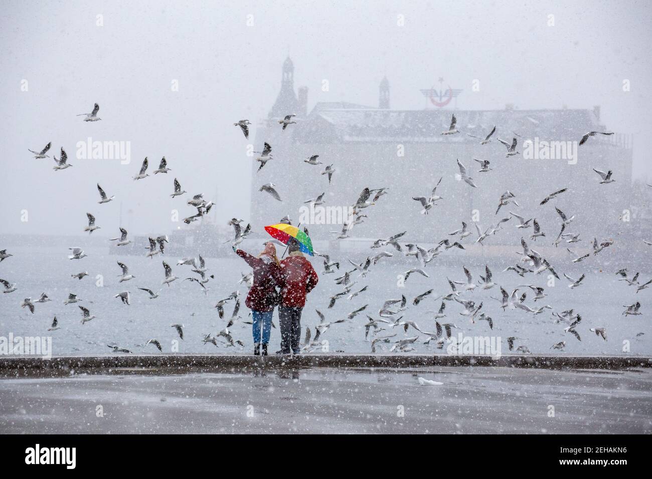 Verliebtes Paar, das bei starkem Schneefall an der Küste von Kadikoy steht. Zum ersten Mal nach einer langen Pause, Istanbul. Stockfoto
