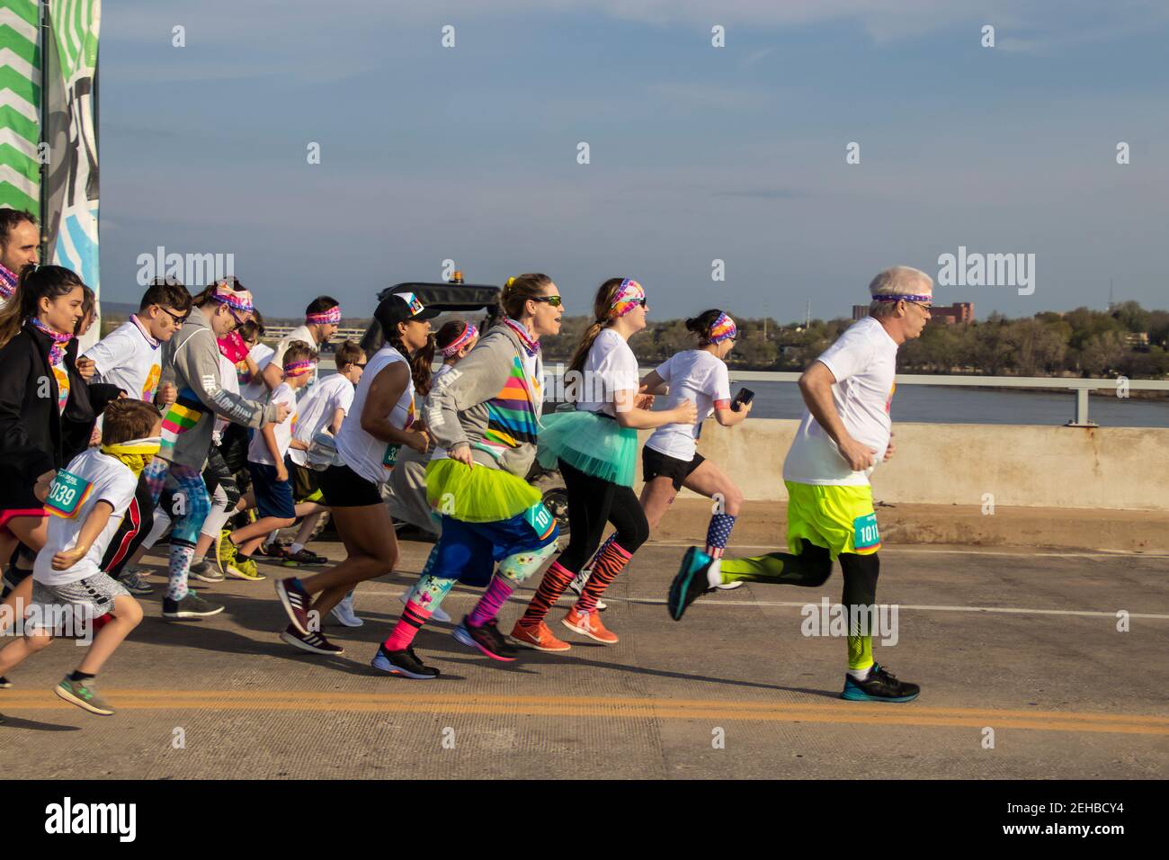4-6-2019 Tulsa USA bunt gekleidet stürmen die ersten Läufer aus Das Tor im Color Run Rennen über die 21st Street Bridge Stockfoto