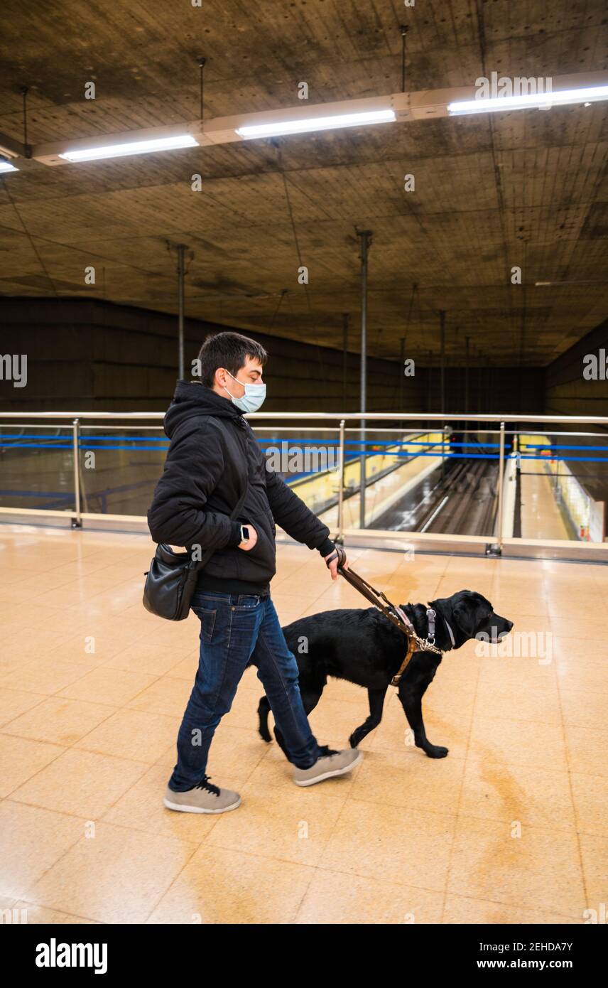 Blinder Mann, der mit dem Blindenhund in der U-Bahn läuft Stockfoto