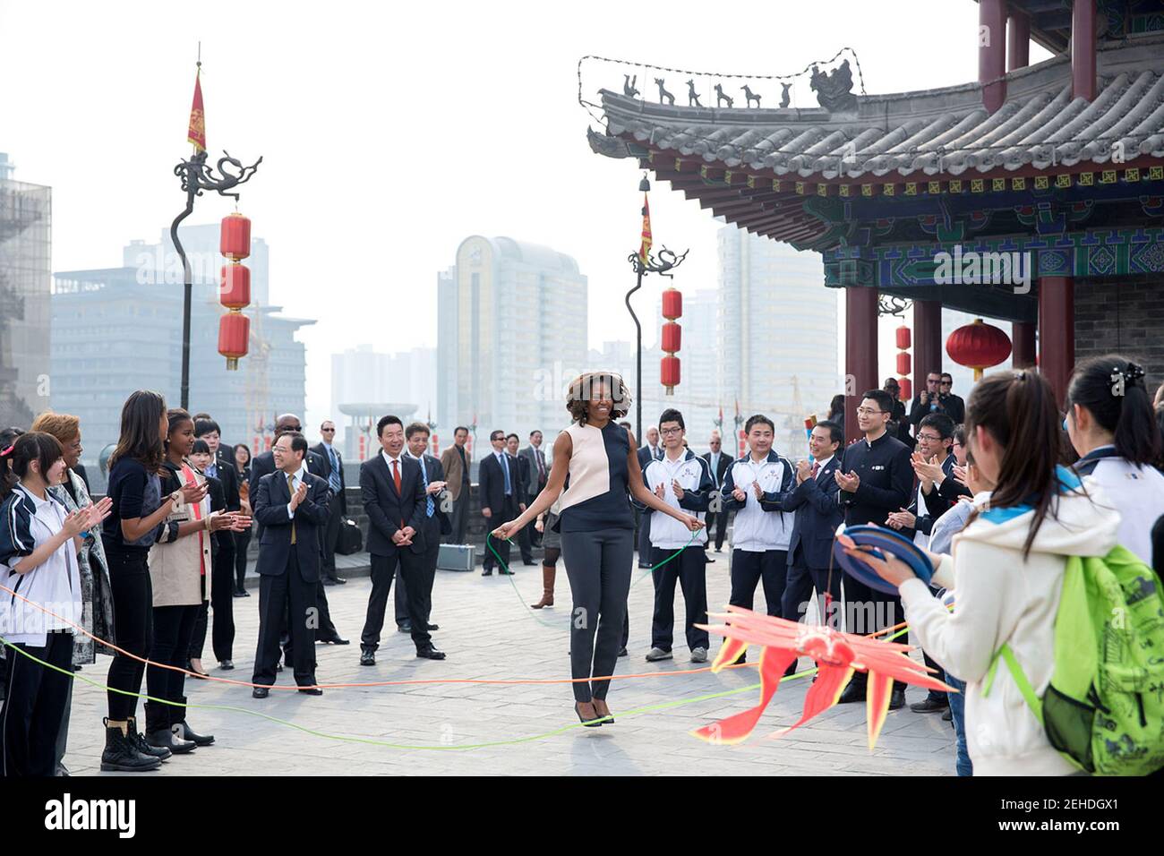 First Lady Michelle Obama, begleitet von den Töchtern Sasha und Malia, und Marian Robinson, springt Seil, während Kinder Spiele während eines Besuchs an der Stadtmauer in Xi'an, China, 24. März 2014 demonstrieren. Stockfoto