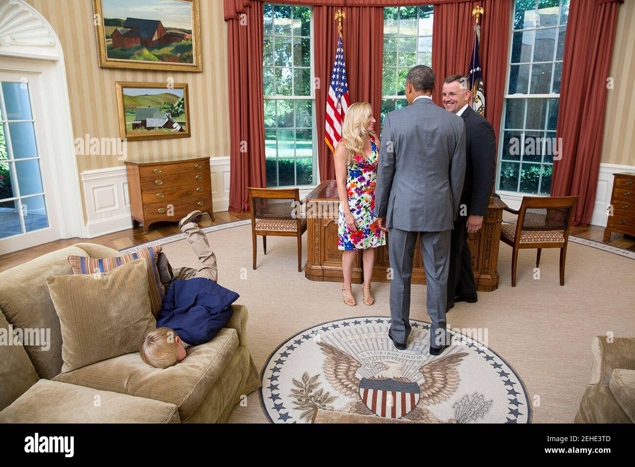 Präsident Barack Obama besucht mit einem ausgeschiedenen United States Secret Service-Agent und seine Frau als ihren Sohn Tauchgänge in eine Couch im Oval Office, 23. Juni 2014. Stockfoto