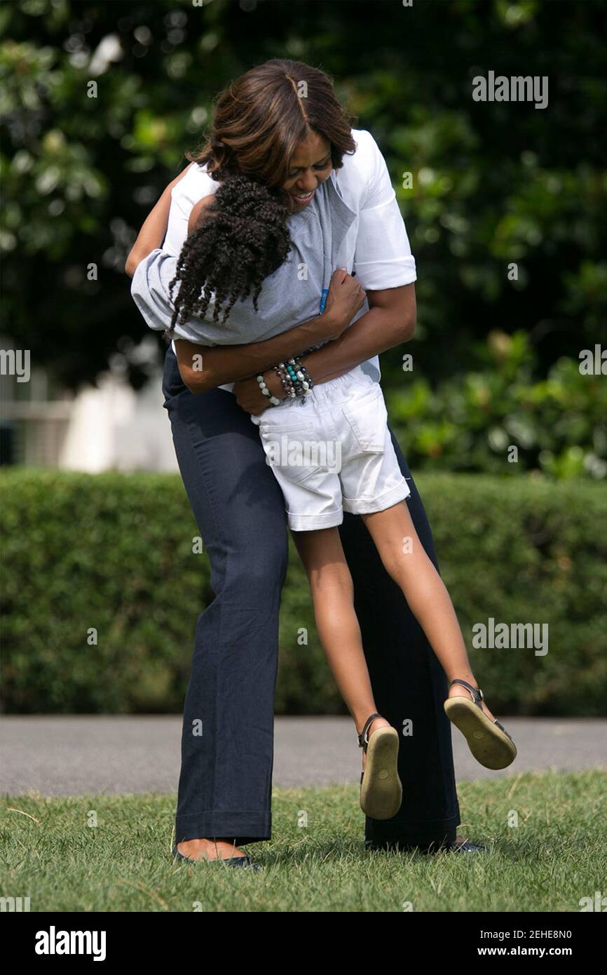 First Lady Michelle Obama umarmt ein Kind während eines Drink-up-Events auf dem South Lawn des Weißen Hauses, 22. Juli 2014. Stockfoto
