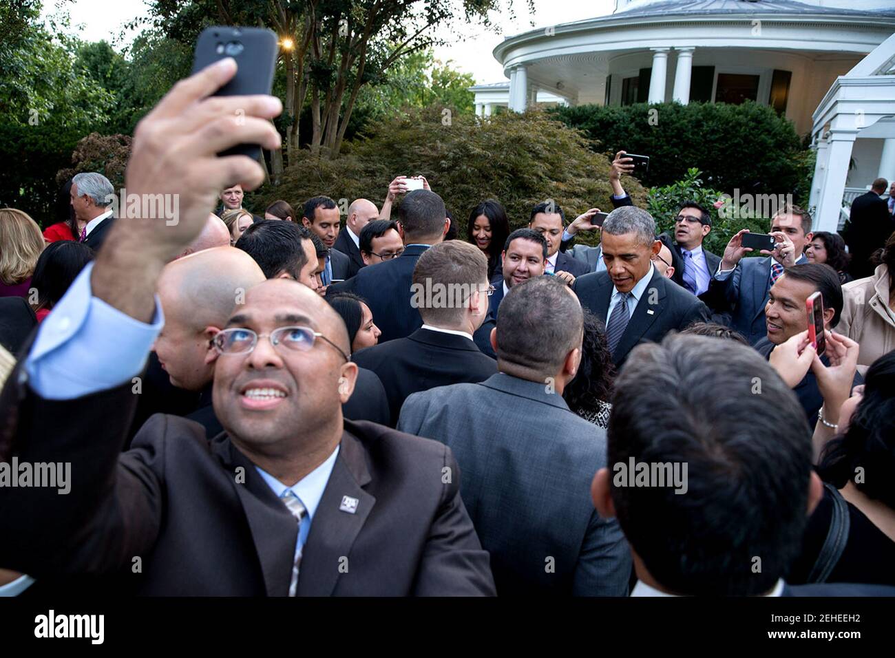 Gast nimmt eine Selfie, wie Präsident Barack Obama Teilnehmer im Rahmen eines Empfangs zu Ehren des Hispanic Heritage Month, der Vice President Residence am Naval Observatory in Washington, D.C., 22. September 2014 von Vize-Präsident Joe Biden und Dr. Jill Biden gehostet begrüßt. Stockfoto