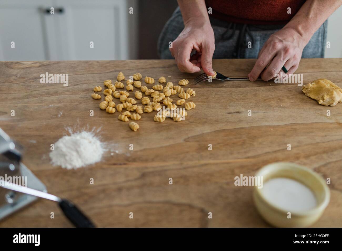 Nahaufnahme der Hände von erwachsenen Männern, die Pasta und Gnocchi zu Hause herstellen. Stockfoto