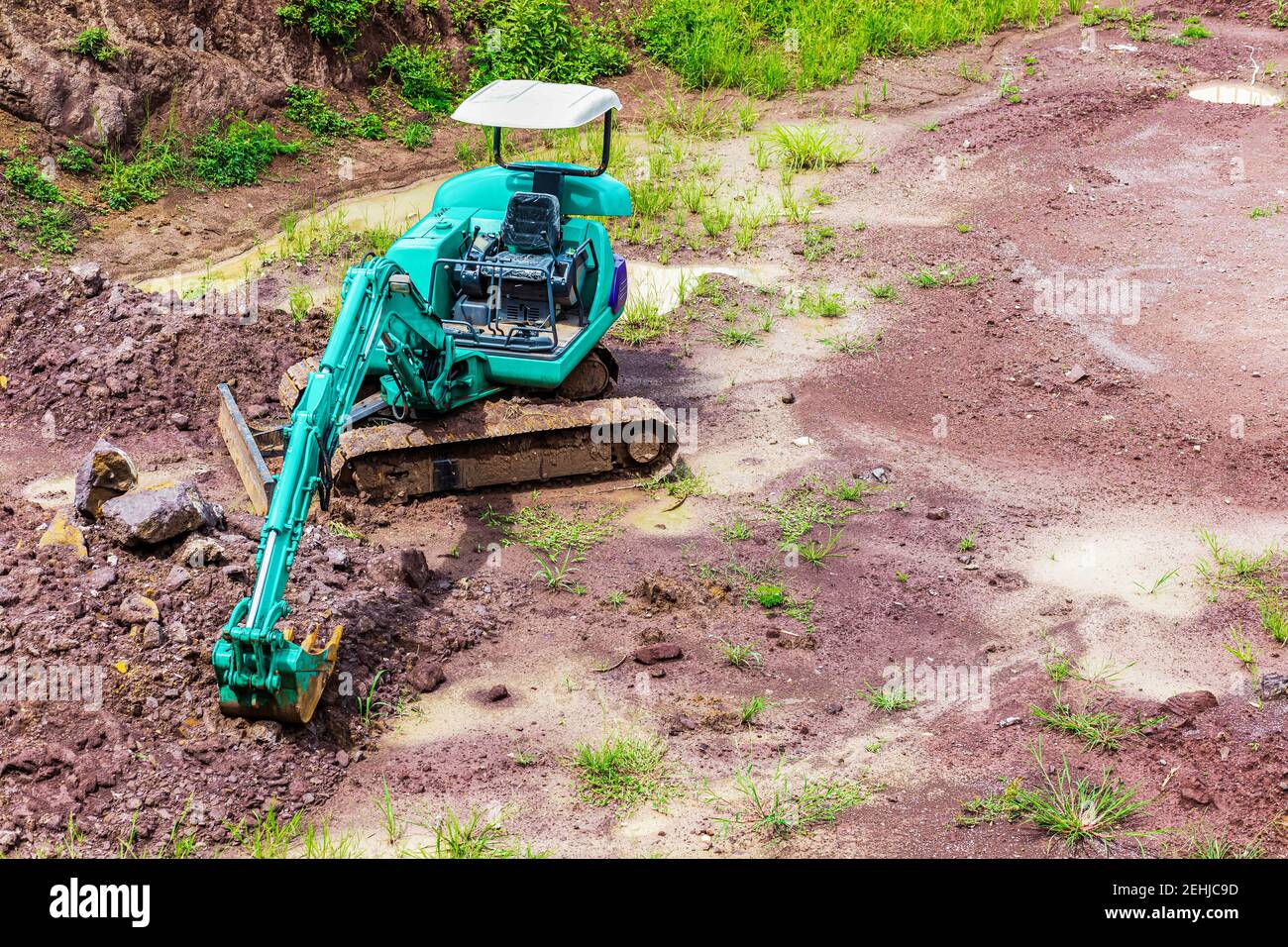 Minibagger ist auf der Baustelle am Boden. Stockfoto