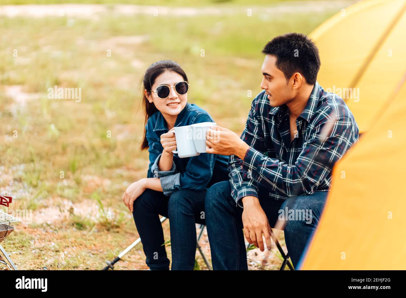 Paare trinken gemeinsam Kaffee während des morgendlichen Campings. Stockfoto