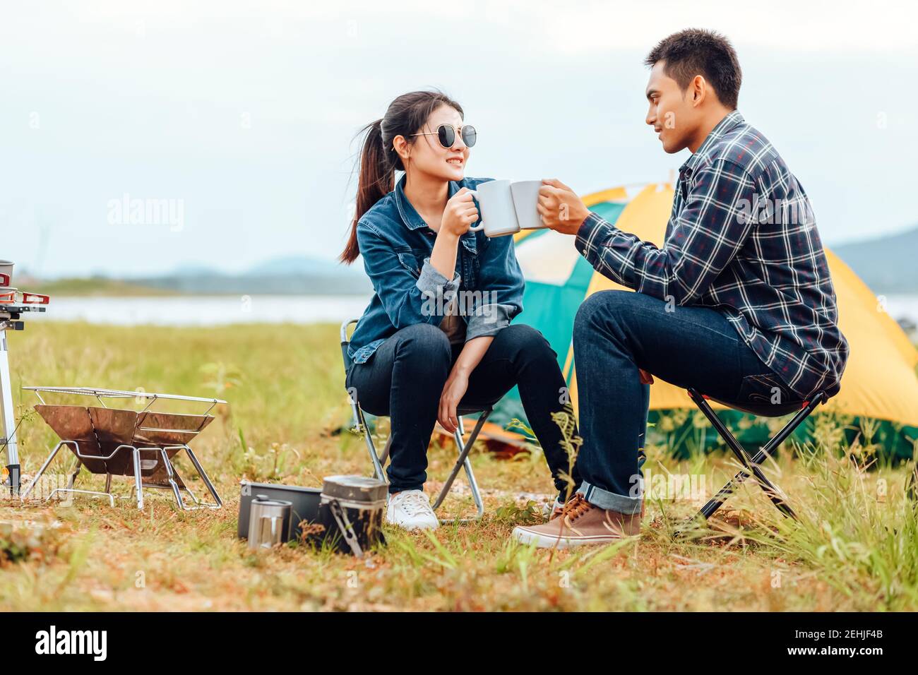 Paare trinken gemeinsam Kaffee während des morgendlichen Campings. Stockfoto