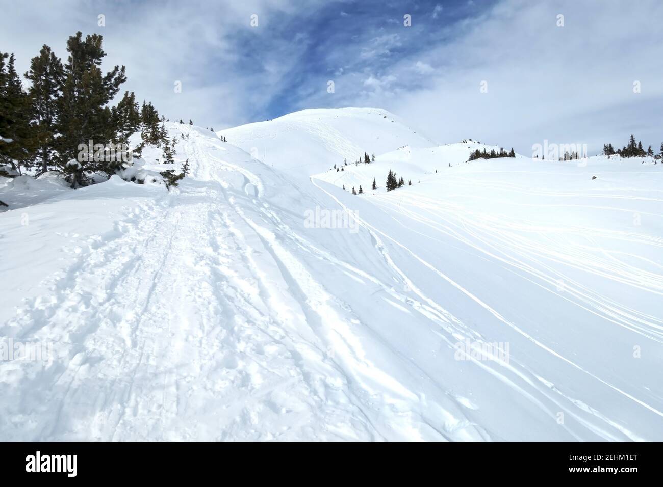 Schneeschuh- und Ski-Tracks in White Snow Klettern entfernt Mountain Peak. Landschaftlich reizvolle Banff National Park Landschaft an einem kalten Wintertag in den kanadischen Rockies Stockfoto