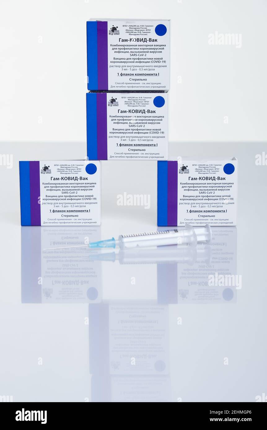 Moskau, Russland – 10. Februar 2021: Pyramide von Impfstofffläschchen und -Boxen mit Sputnik V-Impfstoff Gam-COVID-Vac und Binde auf weißem Tisch mit Reflexion. Stockfoto