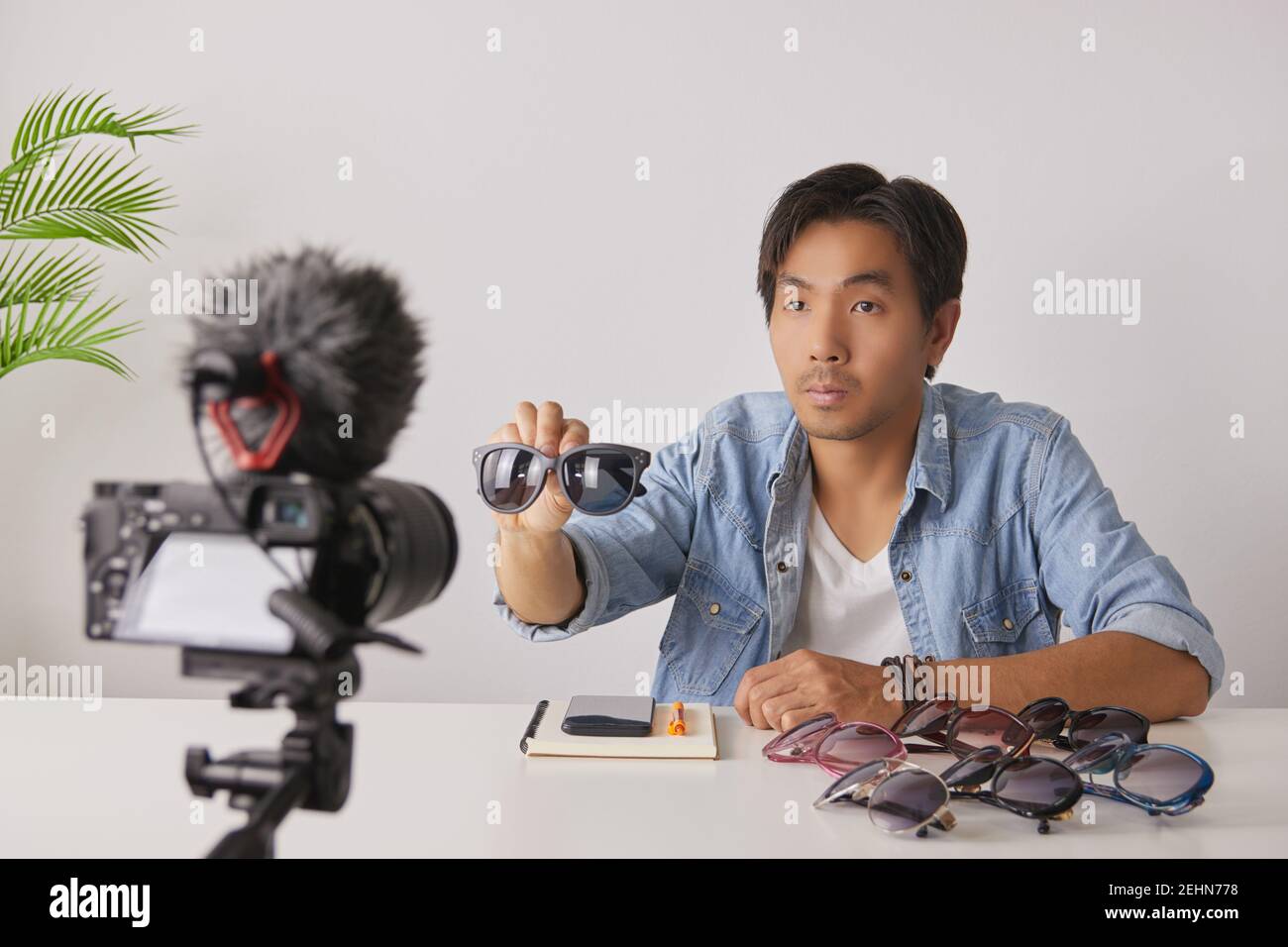 Asiatische Vlogger oder Blogger zeigen schwarze Mode-Brille mit Kunden vor der Kamera und Aufnahme von Video. Freelancer Online Live Streaming mit Custom Stockfoto