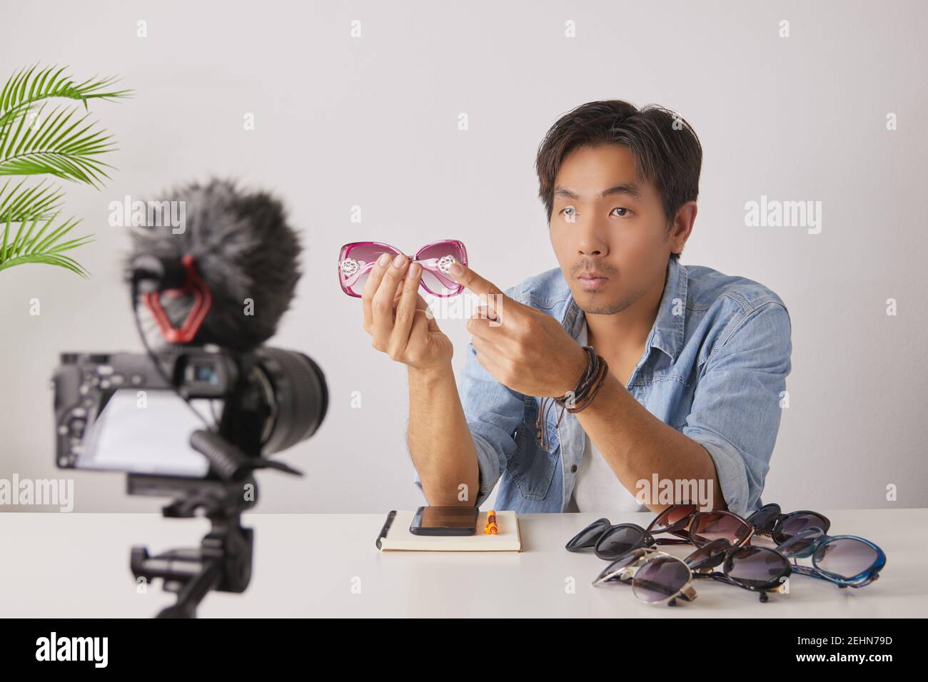 Asiatische Vlogger oder Blogger Bewertung rosa Mode-Brille mit Kunden von Punkt an Brille Bein und Aufnahme Video. Freelancer Online Live Streaming mit Stockfoto