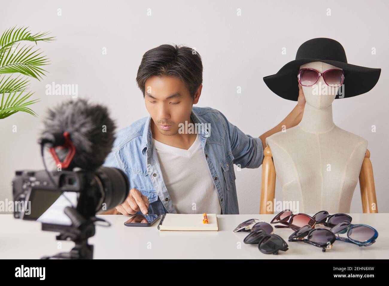 Asiatische Vlogger oder Blogger mit Schaufensterpuppen mit Smartphone zu überprüfen, Bestellung und Chat mit Kunden während der Aufnahme von Video. Freelancer Online Live Streamin Stockfoto