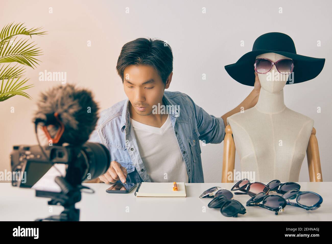 Asiatische Vlogger oder Blogger mit Schaufensterpuppen mit Smartphone zu überprüfen, Bestellung und Chat mit Kunden während der Aufnahme von Video. Freelancer Online Live Streamin Stockfoto