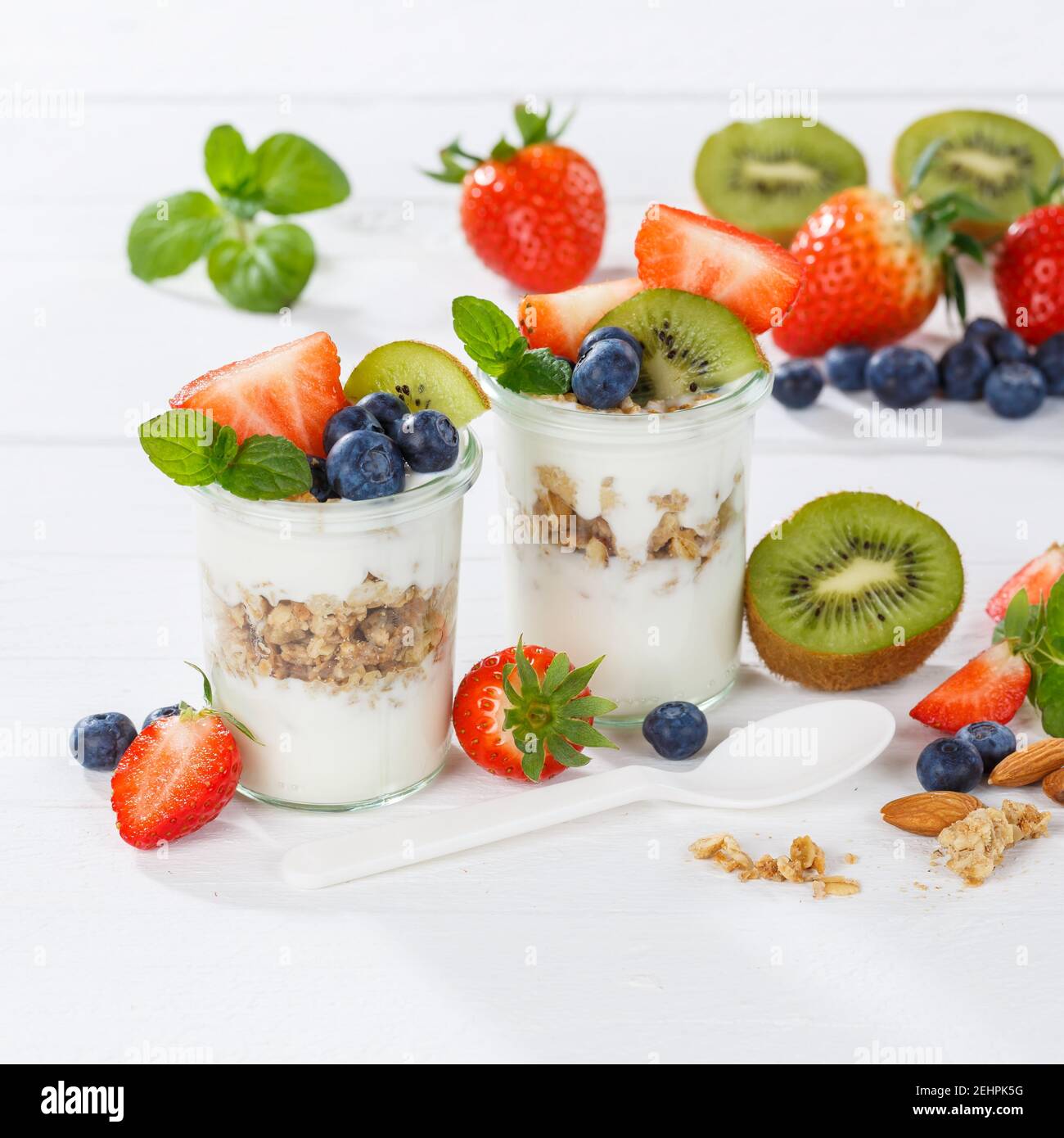 Erdbeer Joghurt Obst Frühstückslöffel gesund essen Joghurt Essen auf Ein Holzbrett Quadrat Stockfoto