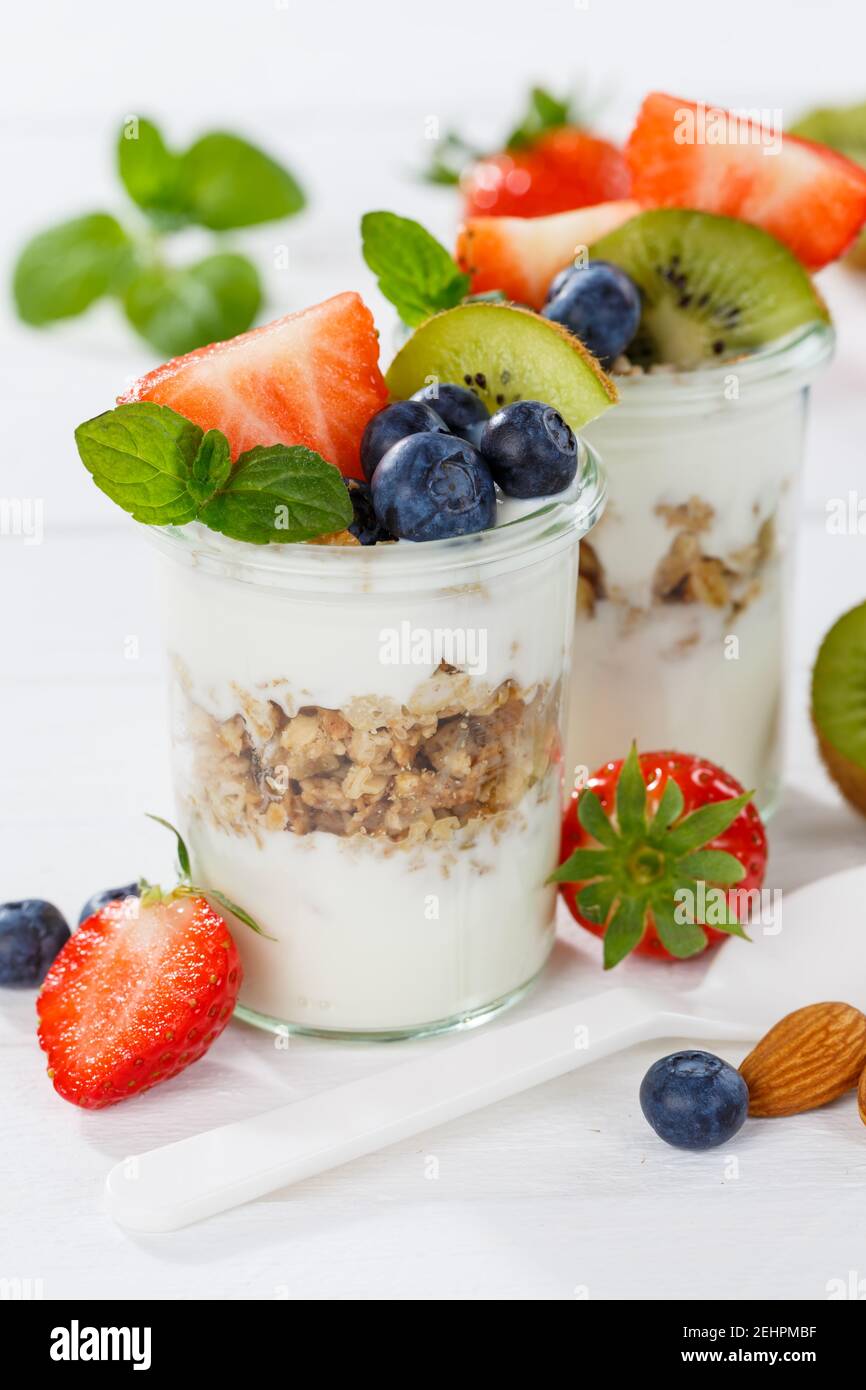 Erdbeer Joghurt Obst Frühstückslöffel gesund essen Joghurt Essen auf Ein Holzbrett Hochformat Stockfoto