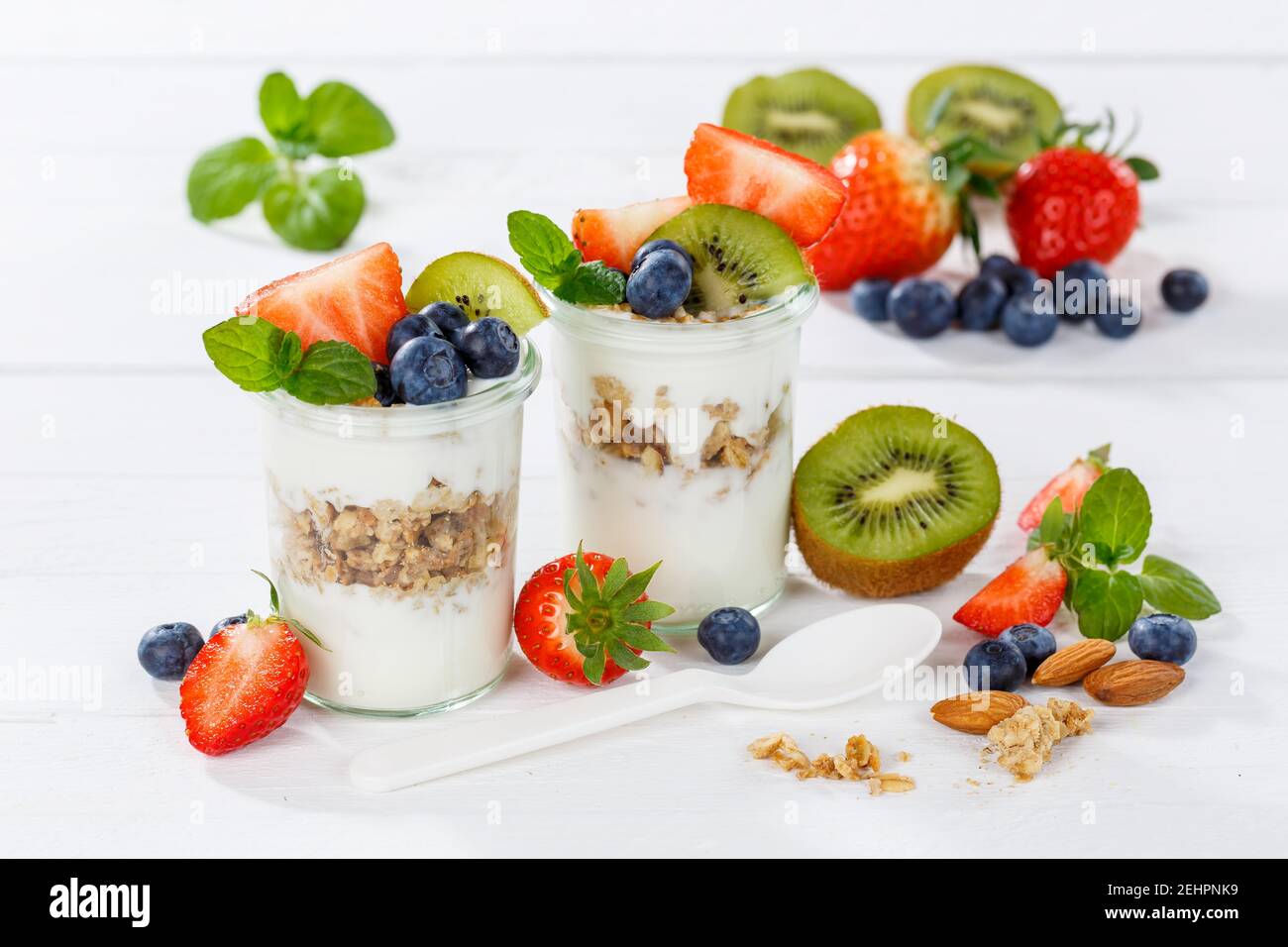 Erdbeer Joghurt Obst Frühstückslöffel gesund essen Joghurt Essen auf Ein Holzbrett Stockfoto