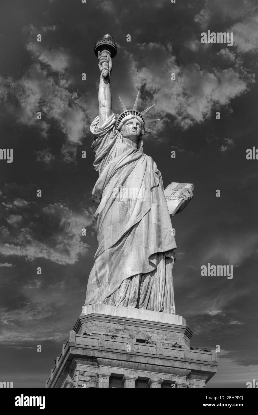 Die Freiheitsstatue in New York City USA Tageslicht Nahaufnahme der Low-Angle-Ansicht in Schwarzweiß mit Wolken am Himmel Stockfoto