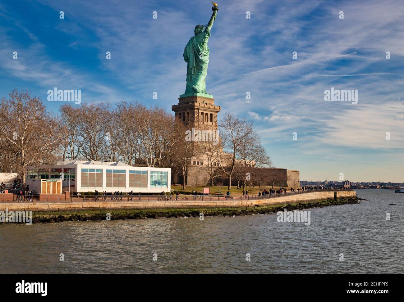 Die Freiheitsstatue in New York City USA Tageslicht Blick von hinten auf Liberty Island mit Wolken Der Himmel im Hintergrund Stockfoto