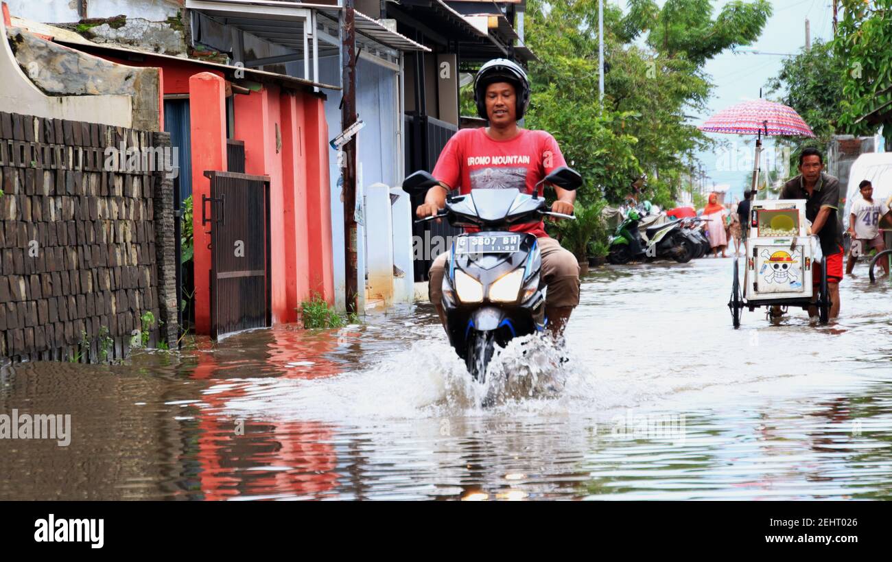 Sehr nicht fokussieren Bild, Bewohner, wie sie durch ein Hochwasser auf ihrer Dorfstraße passieren, Pekalongan, Indonesien, 19. Februar 2021 Stockfoto