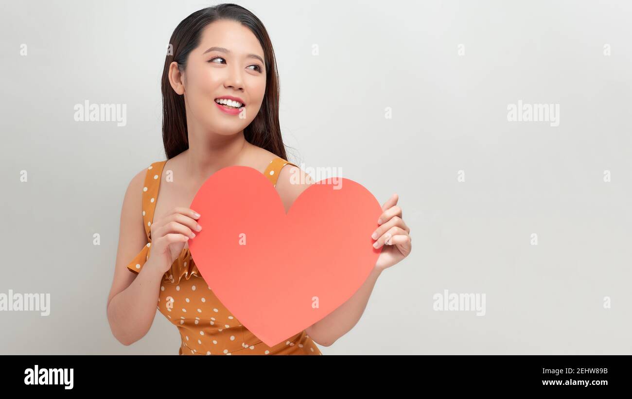 Frau hält großes rotes Herz auf weißem Hintergrund Stockfoto