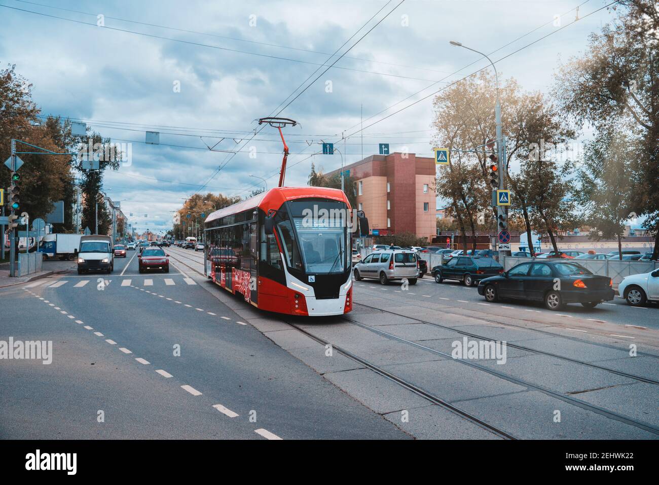 Rot-weiß moderne Straßenbahn auf der Straße in Perm, Russland. Neue Straßenbahnen für russische Städte. Stockfoto