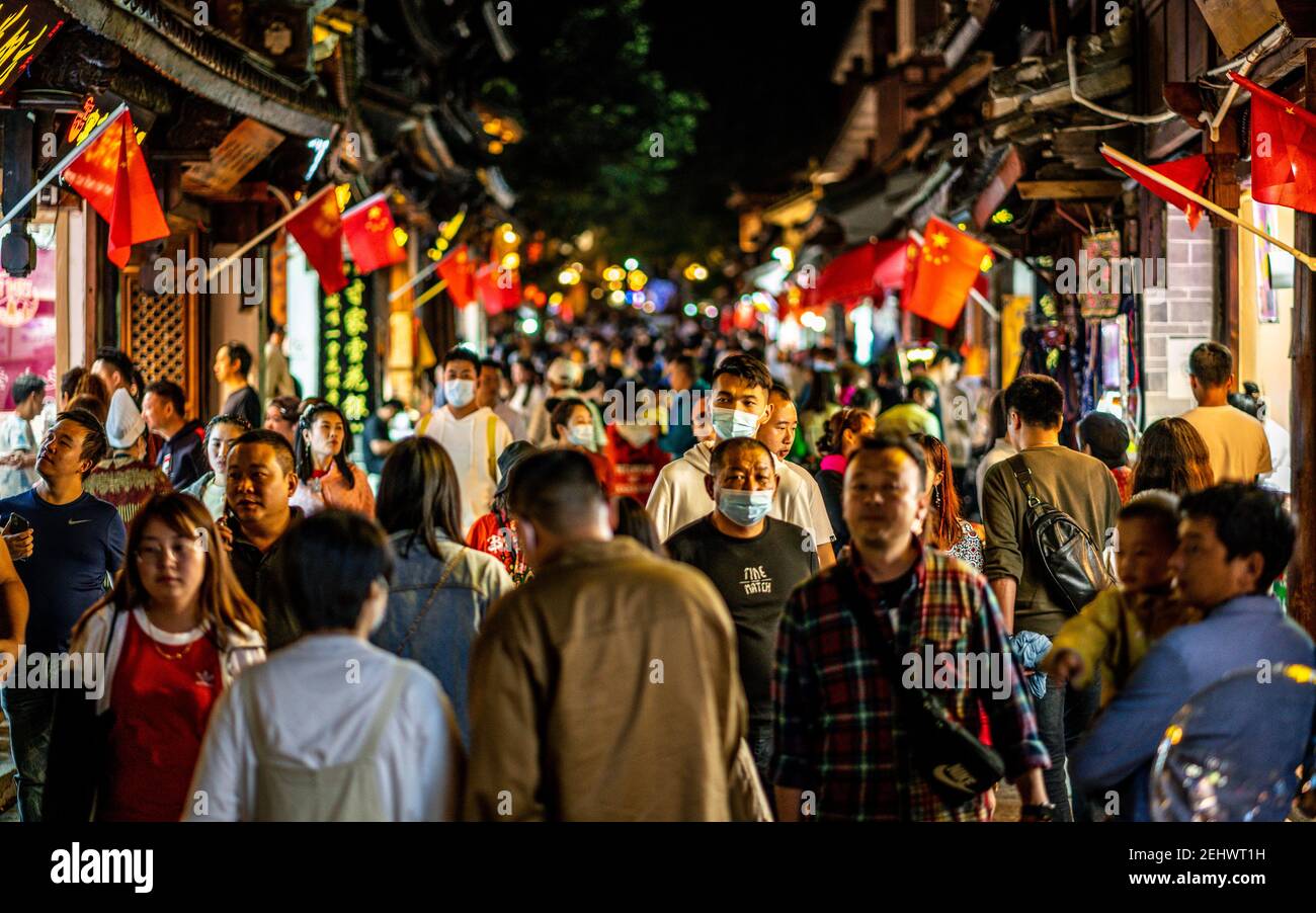 Dali China , 5. Oktober 2020 : Menschenmenge von Chinesen in Dali Altstadt in der Nacht mit Mann trägt Gesichtsmaske während 2020 goldene Woche in Dali Yunnan Chin Stockfoto
