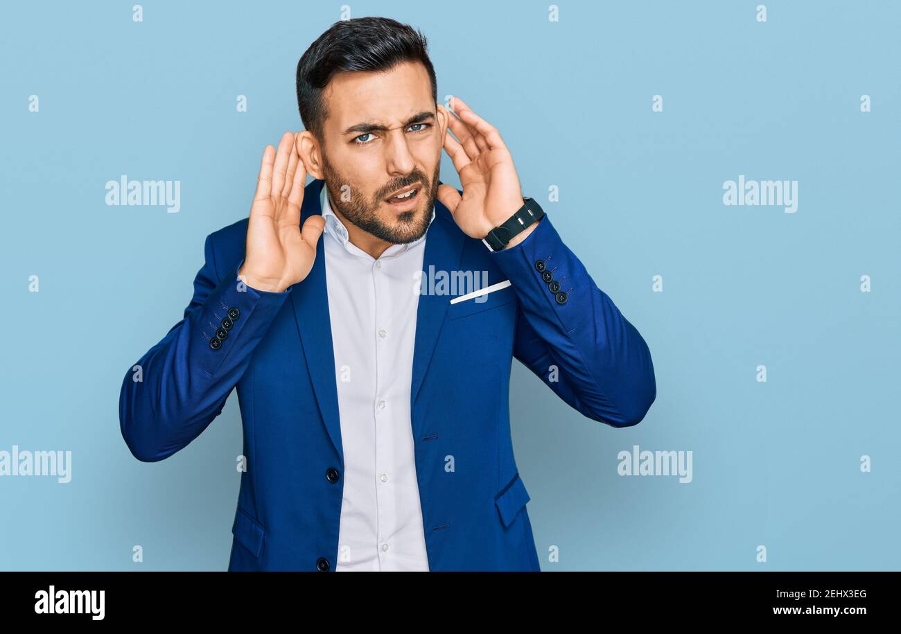 Junge hispanic Mann trägt Business Jacke versucht, beide Hände auf Ohr Geste hören, neugierig auf Klatsch. Hörproblem, taub Stockfoto