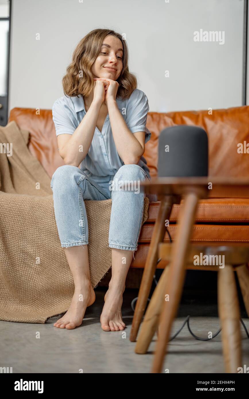 Frau hören Audio-Assistent Spalte sitzen auf dem Sofa Stockfoto