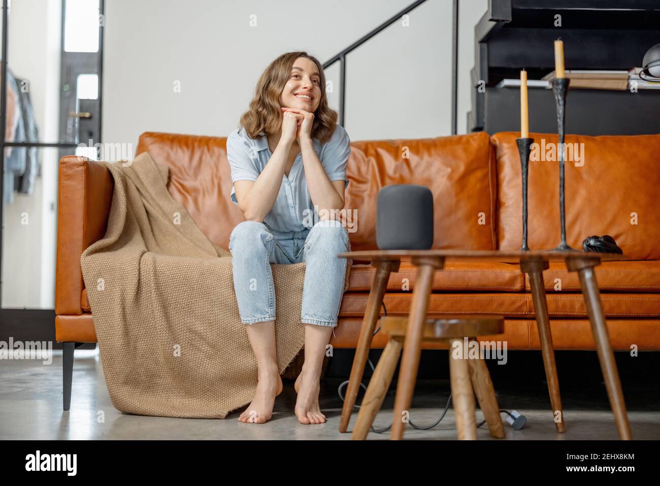 Frau hören Audio-Assistent Spalte sitzen auf dem Sofa Stockfoto