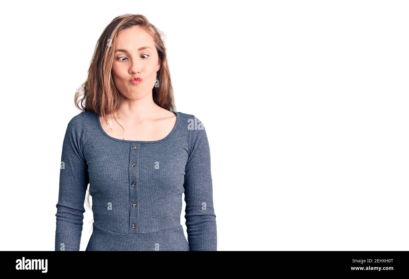 Junge schöne blonde Frau trägt Freizeitkleid machen Fisch Gesicht mit Lippen, verrückt und komische Geste. Lustiger Ausdruck. Stockfoto