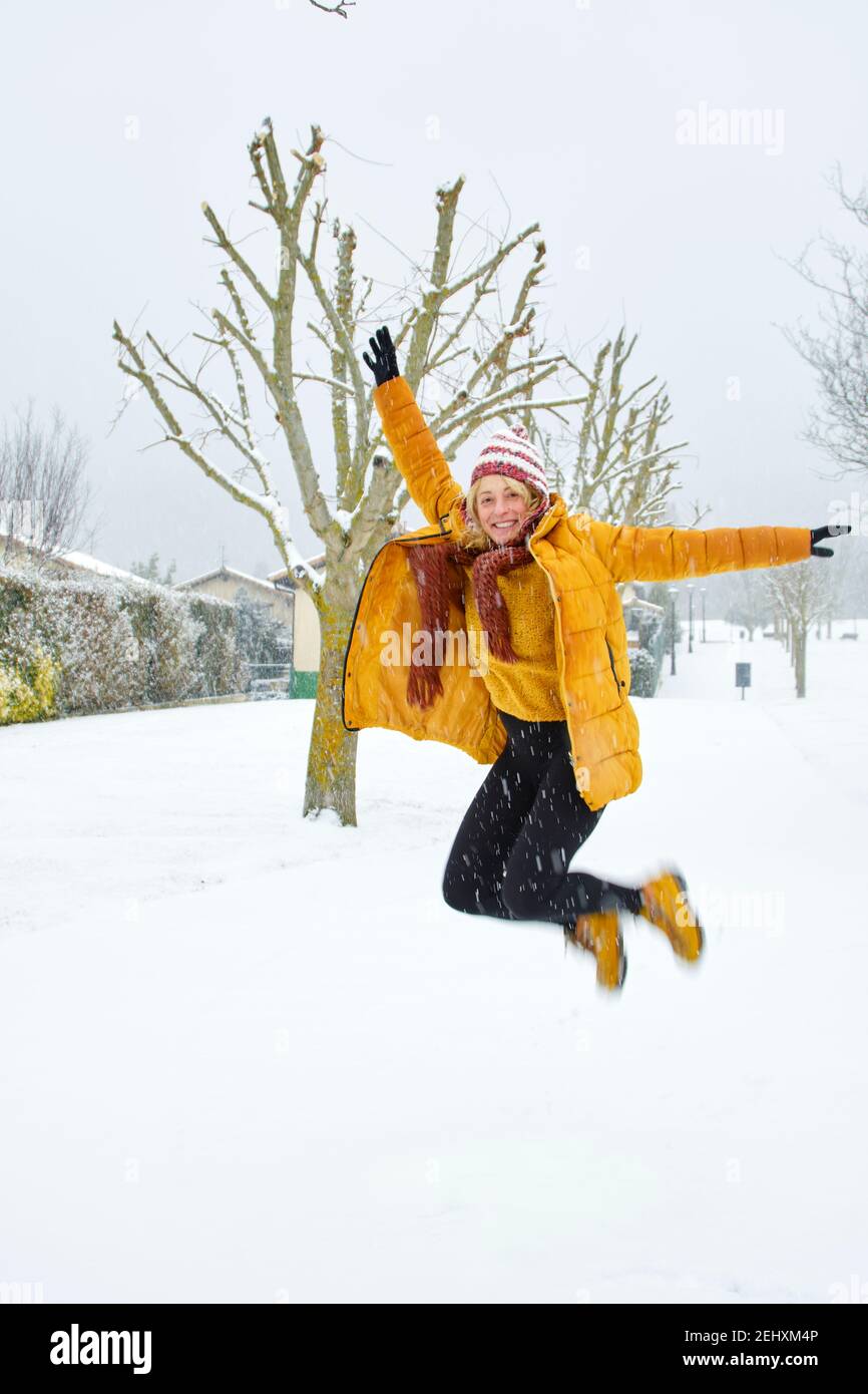 Kaukasische junge Frau springen im Schnee im Freien im Winter. Navarra, Spanien, Europa. Stockfoto