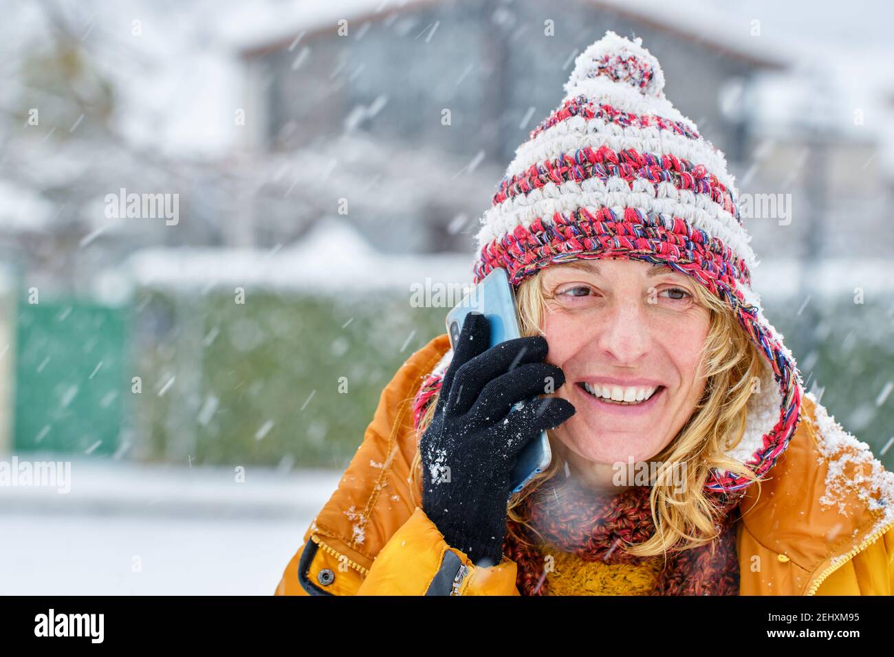 Kaukasische junge Frau genießen mit einem Handy im Schnee im Winter draußen. Navarra, Spanien, Europa. Stockfoto