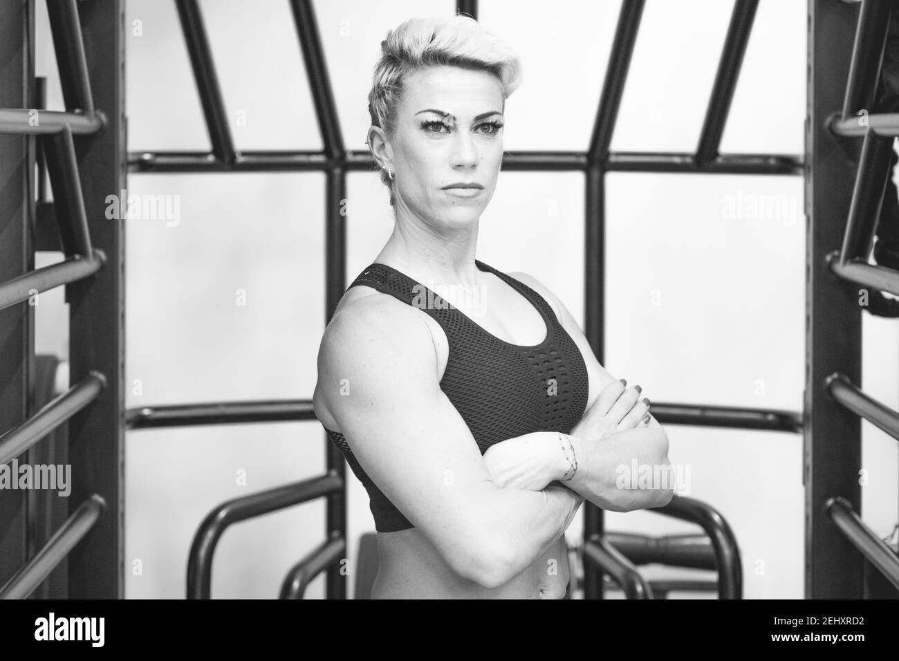 Attraktive Passform selbstbewusste Frau in Sportbekleidung posiert im Fitnessstudio In schwarz und weiß Stockfoto