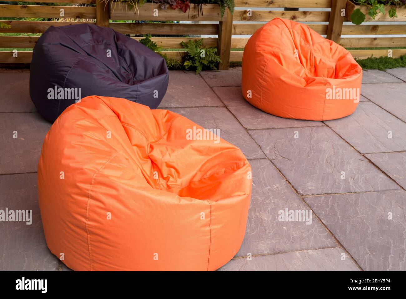 Große orange und schwarz Sitzsack Stühle auf einem Stein Gepflasterte Terrasse England GB Großbritannien Stockfoto
