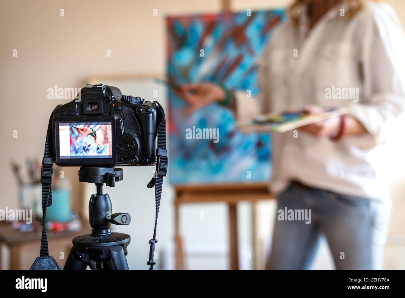 Art Painter Live-Streaming aus ihrem Studio. Freischaffender Künstler. Kreative Frau vlogging ihre Malerei Technik und Geschicklichkeit. Kamera auf Stativ Aufnahme Stockfoto