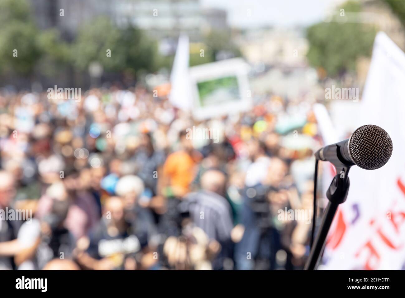 Fokus auf mikrofon, verschwommene Gruppe von Menschen bei Massenprotest im Hintergrund Stockfoto