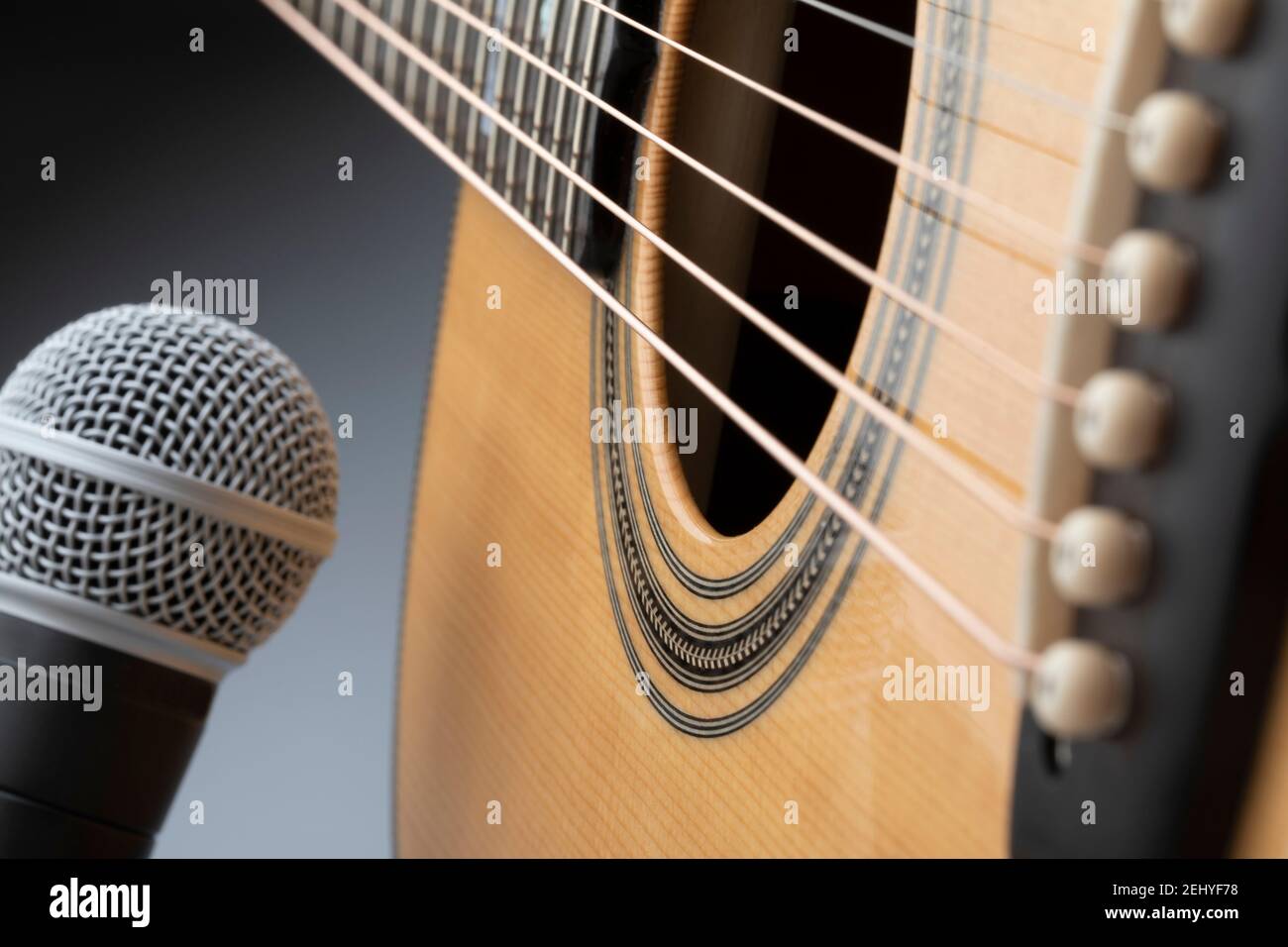 Akustischer Gitarrenkörper mit Mikrofon auf grauem Hintergrund Stockfoto