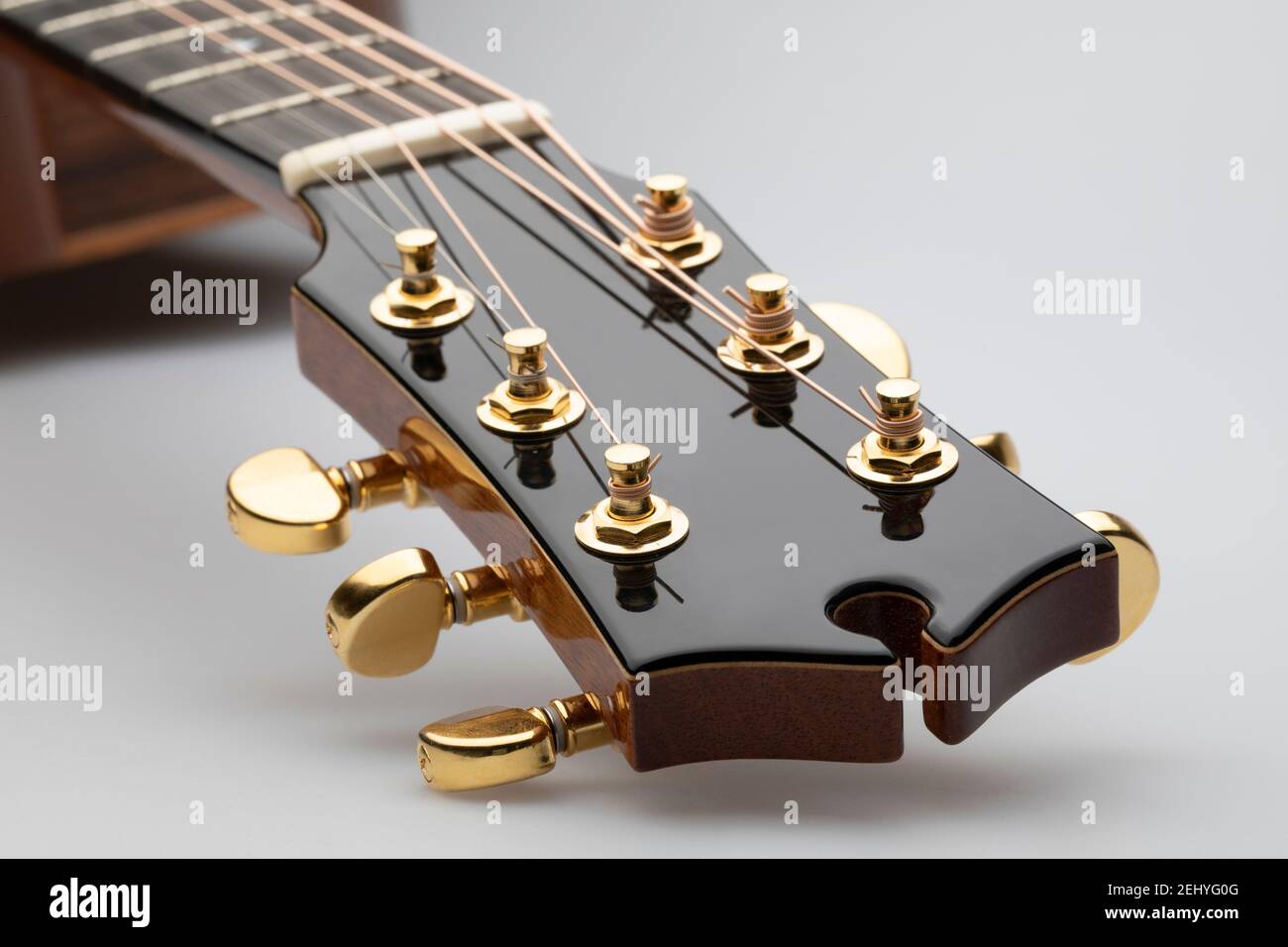Nahaufnahme eines akustischen Gitarrenkopfes mit Stimmtasten Auf weißem Hintergrund Stockfoto