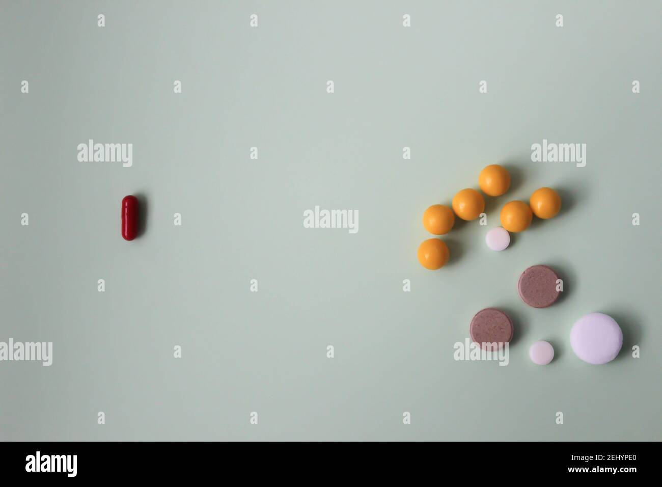 Bunte Vitamintabletten, Medikamententabletten und Kapseln auf abstrakt grünem Hintergrund. Stockfoto