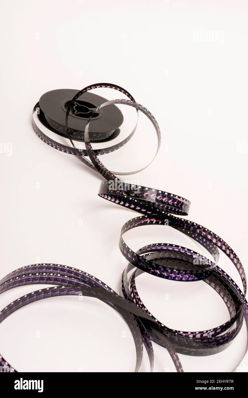 Die Filmrolle wird auf einer weißen Oberfläche mit sichtbaren kreativen Schatten abgelöst Stockfoto