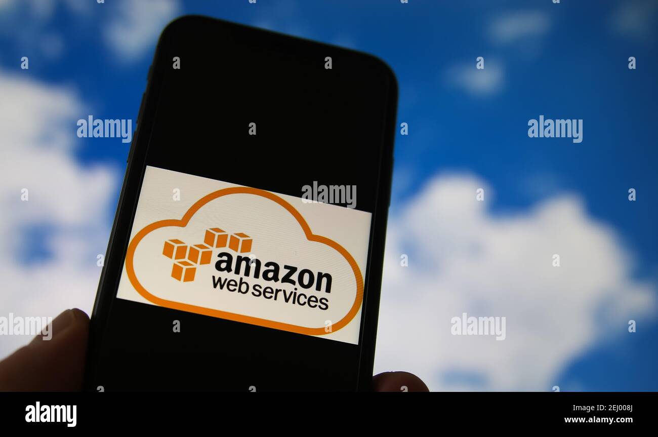 Viersen, Deutschland - Februar 9. 2021: Nahaufnahme des Smartphones mit Logo-Schriftzug des Cloud-Computing-Anbieters Amazon, verschwommener Himmel und Wolkenhinterg Stockfoto