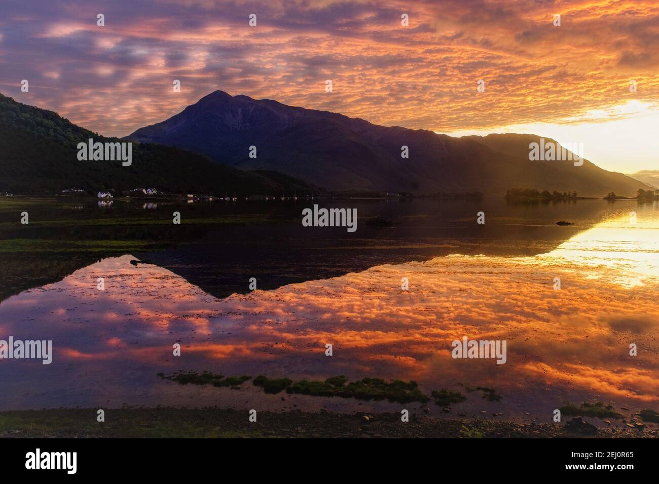 Ein feuriger Sonnenuntergang über Beinn A Bheithir spiegelte sich in Loch Linnhe, Schottische Highlands Stockfoto