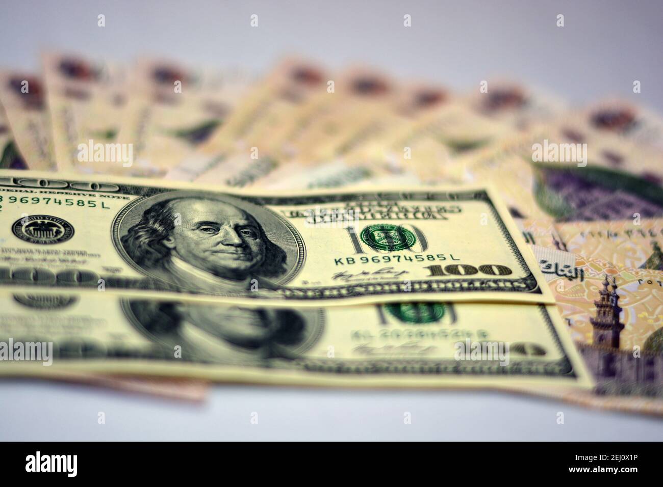 Selektiver Fokus der ägyptischen Landeswährung mit US-Dollar-Banknoten. Verschwommenes Geld. Ägyptisches Geld und amerikanische Dollar Wechselkurs,. Stockfoto