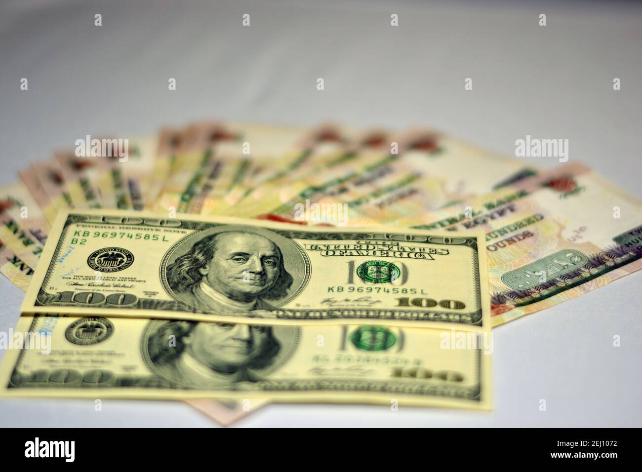 Selektiver Fokus der ägyptischen Landeswährung mit US-Dollar-Banknoten. Verschwommenes Geld. Ägyptisches Geld und amerikanische Dollar Wechselkurs,. Stockfoto