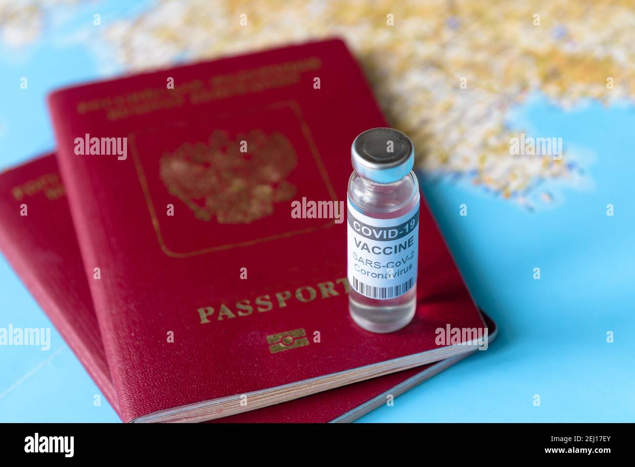 Coronavirus, Reise- und Impfkonzept, Flasche COVID-19-Impfstoff und Pässe auf der touristischen Karte. COVID-Impfung aufgrund von Einschränkungen und Sperrung. Stockfoto